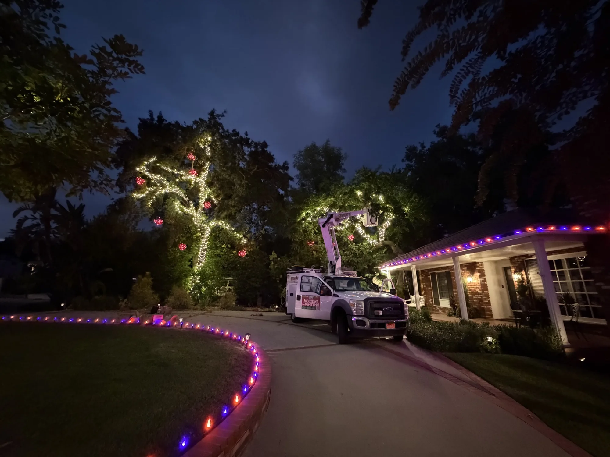 Bee Merry branded bucket truck on-site in the Conejo Valley setting up event lighting