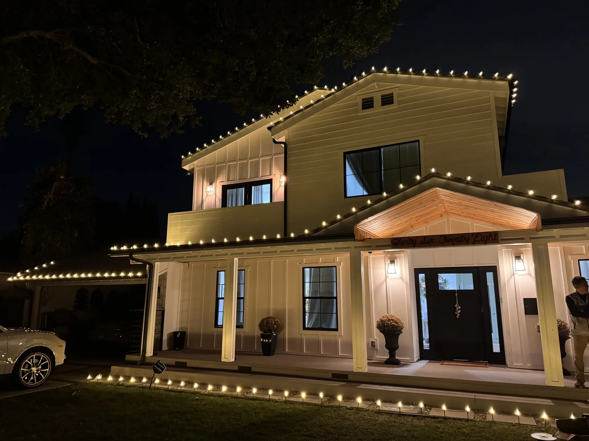 Thousand Oaks farmhouse with warm-white Christmas lights along the roofline at night