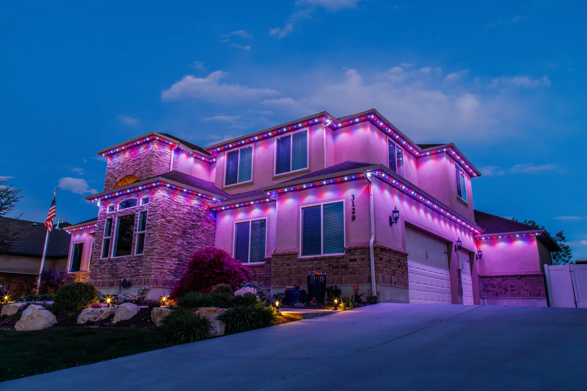 Private estate glowing at blue hour with colored uplighting for a corporate event by Bee Merry